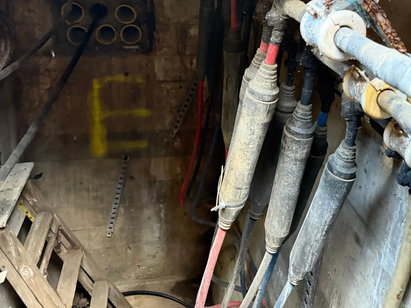 Inside an aging utility vault with decades-old cables and an empty duct bank awaiting upgrade