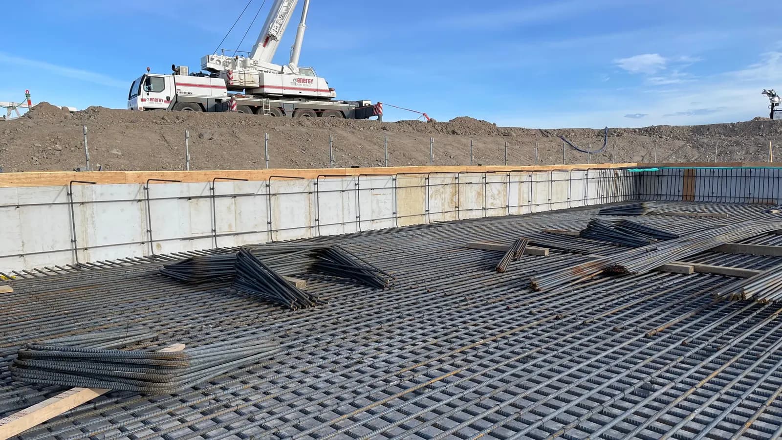 Reinforcing steel mat and formwork prepared for a structural concrete pour with a crane on site