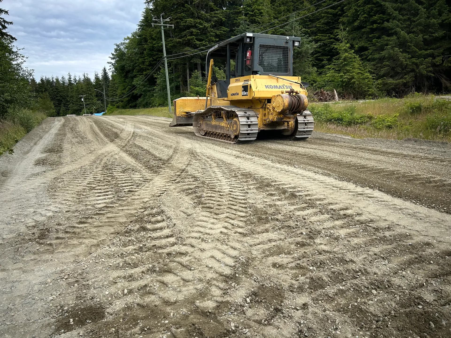 Dozer grading compacted road base on a gravel road