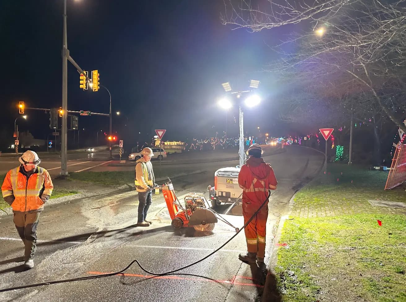 Road crew saw-cutting and restoring pavement during a night shift