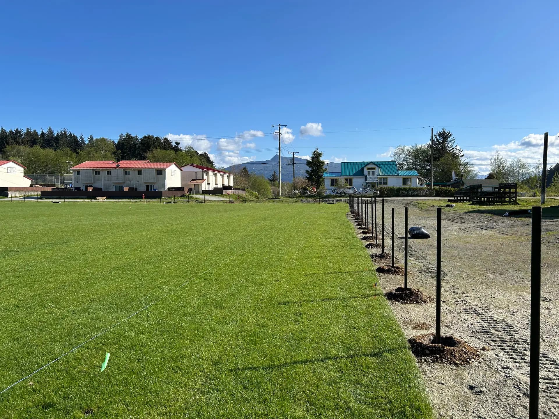 New chain link fence line along a freshly built sports field