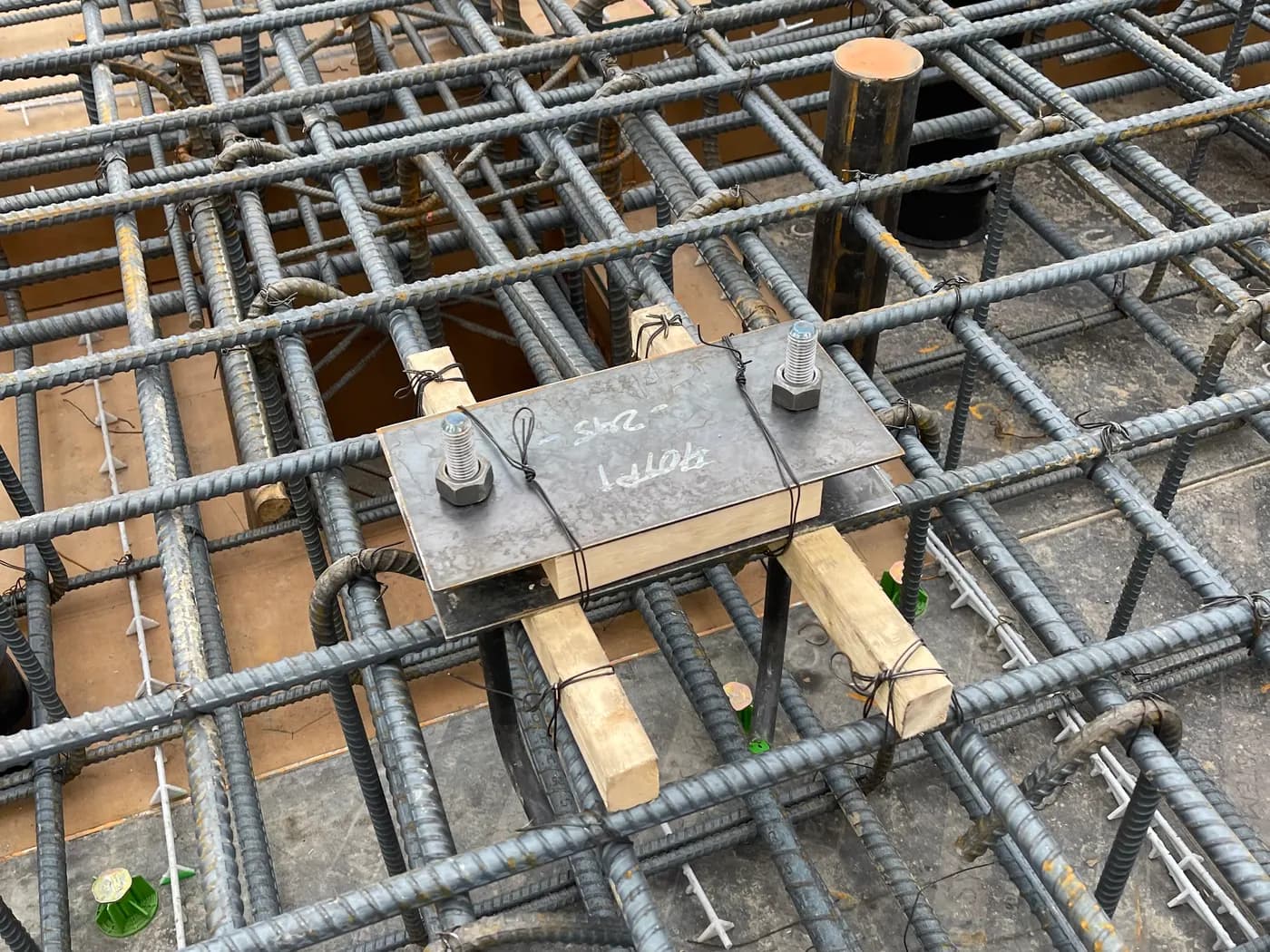 Anchor bolt embed plate set and tied into a dense structural rebar mat before a foundation pour