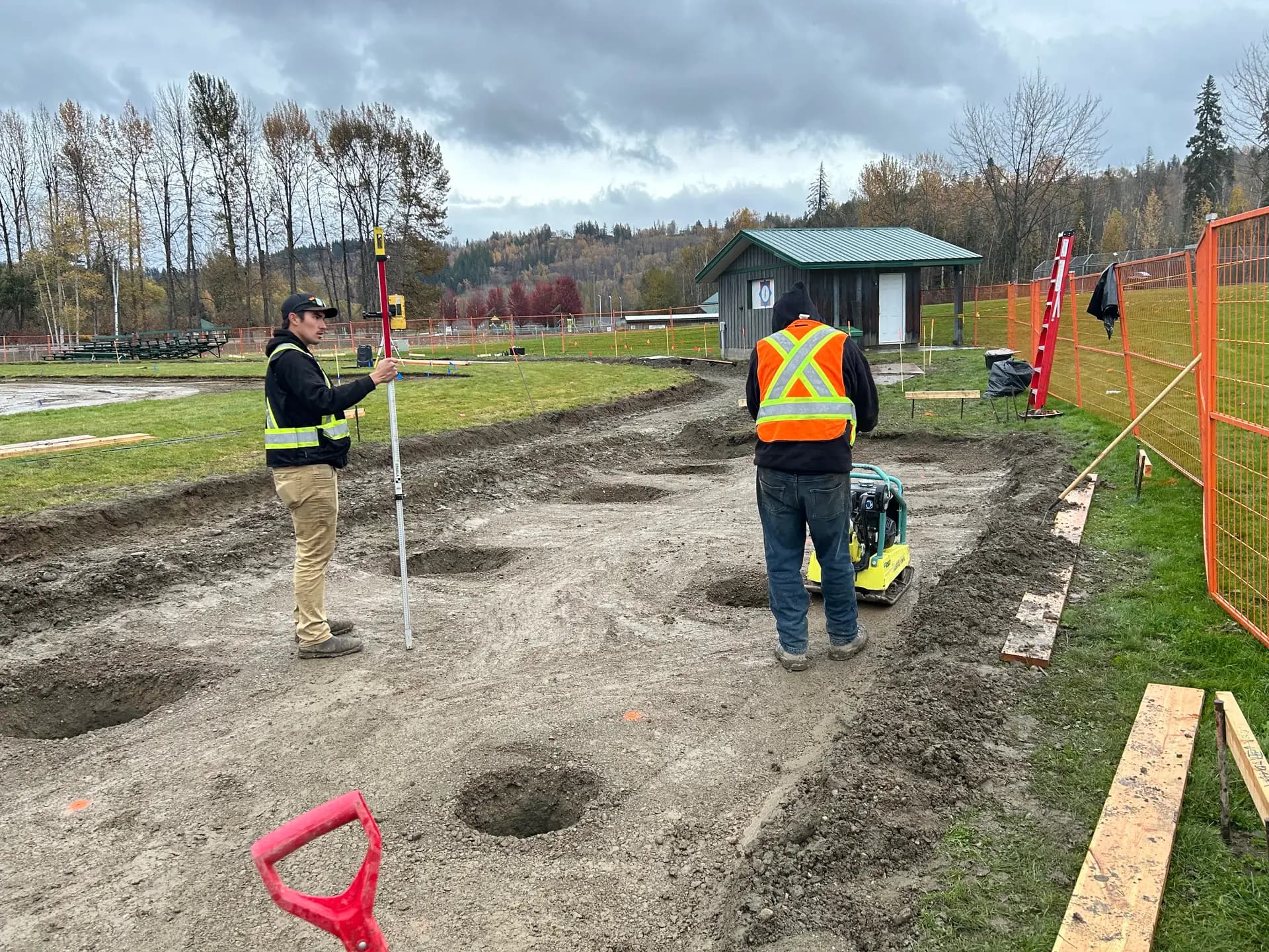 Survey and layout crew setting grade stakes in high-visibility safety gear