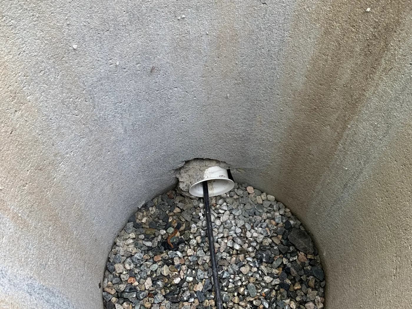 New precast utility vault base with conduit entry and drain rock, ready for cable installation